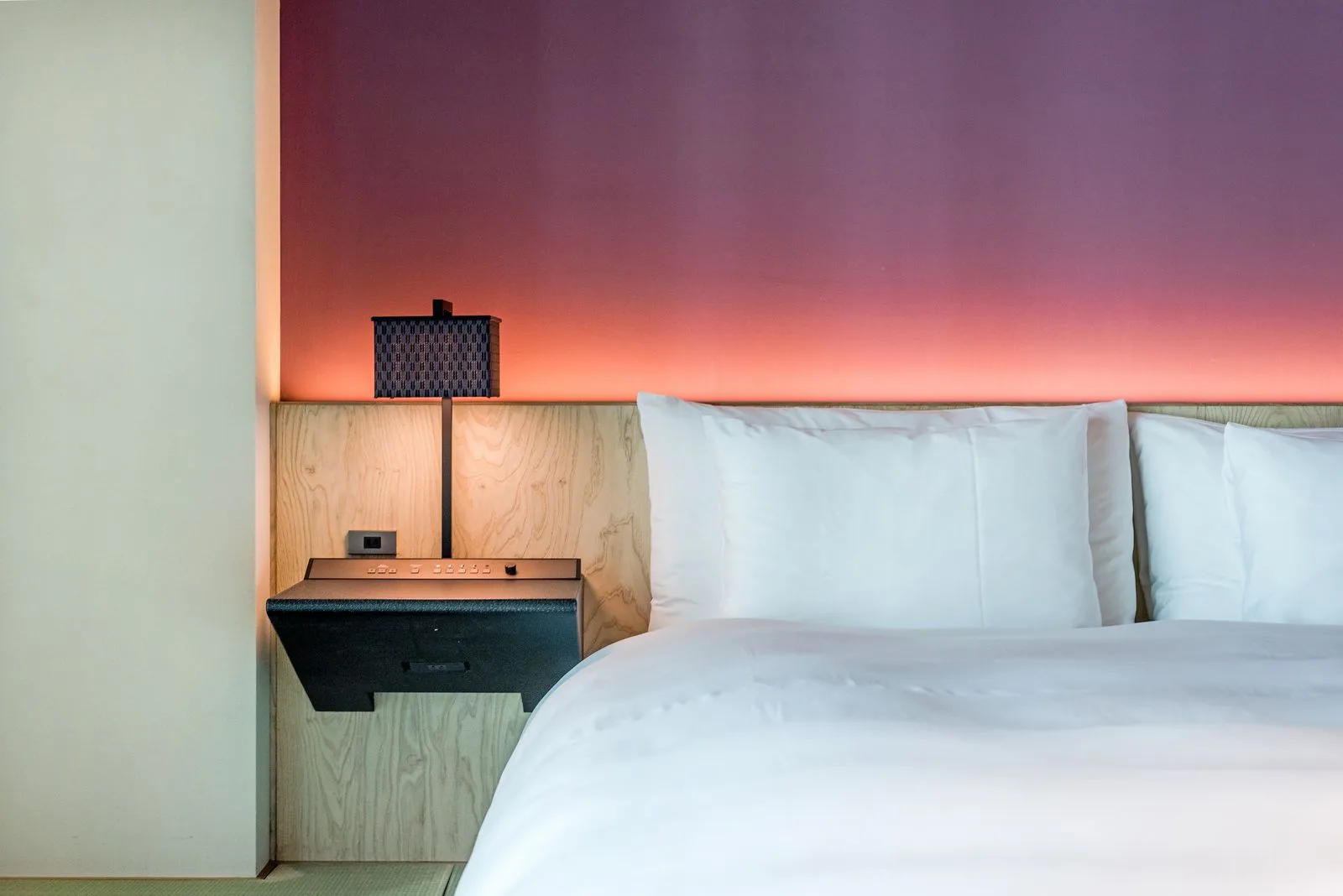 Quarto com cama branca, madeira clara e luz quente