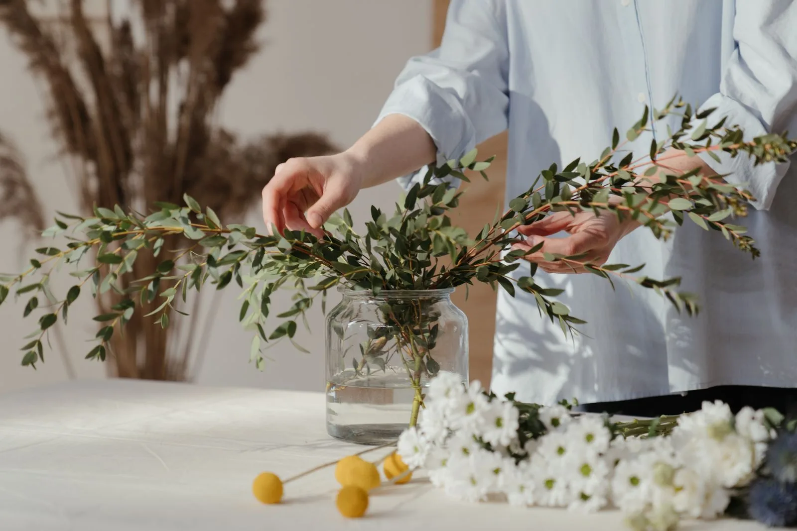Um ramo de flores junto às mãos que o seguram